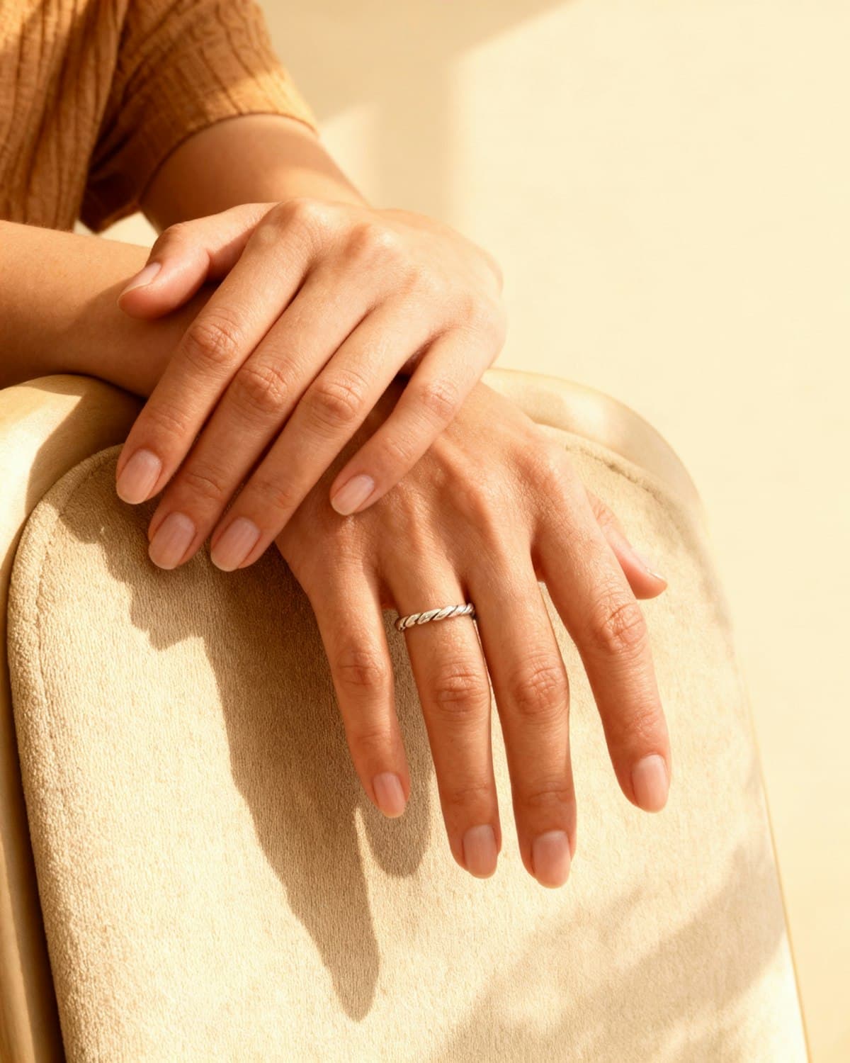 Close up of a pair of hands resting, lit warmly